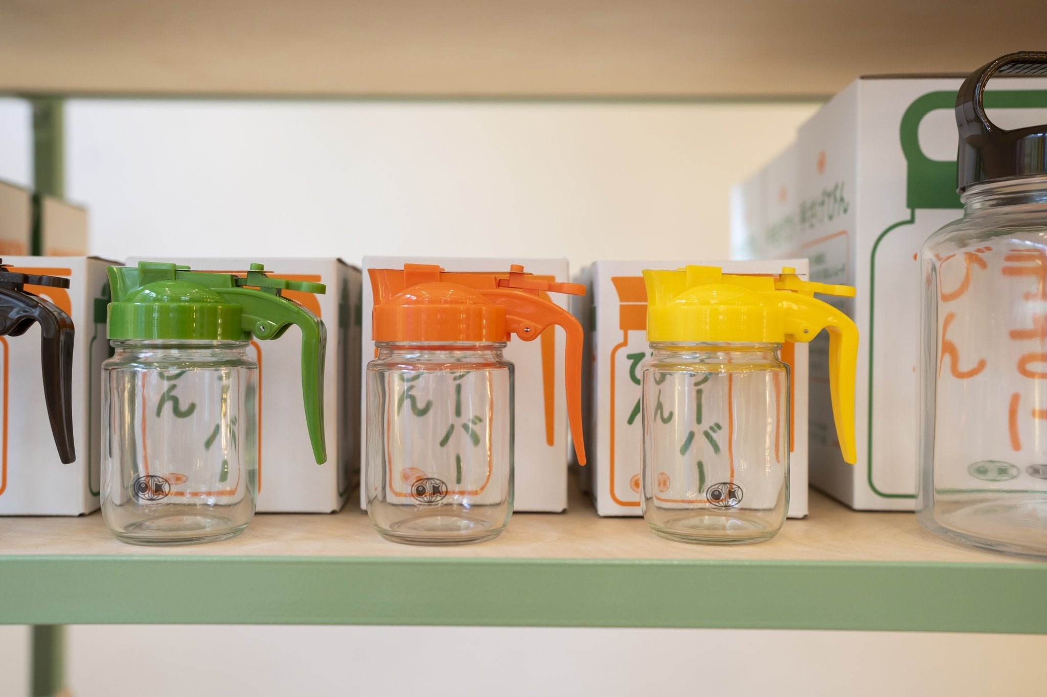 Clear cups with colorful lids on a shelf with boxes in the background