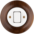 Nucleus fat button light switch by Katy Paty in porcelain with walnut surround